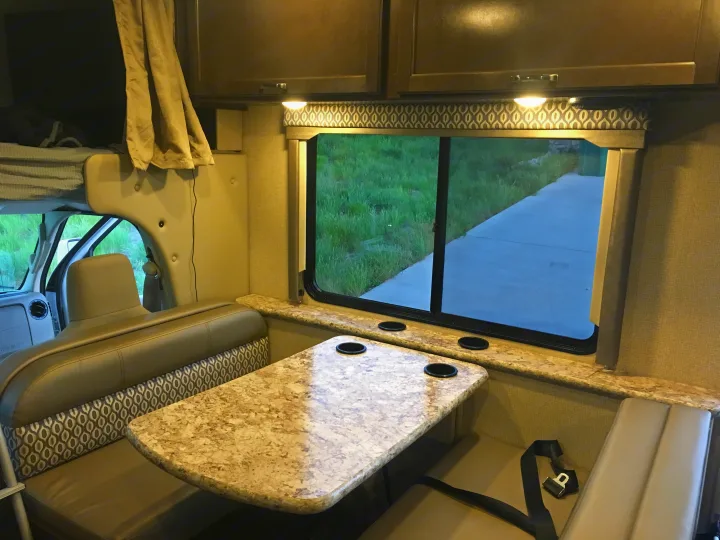RV rental interior: Cozy dinette, bunk bed, and window view inside a camper.. Other Other 2018