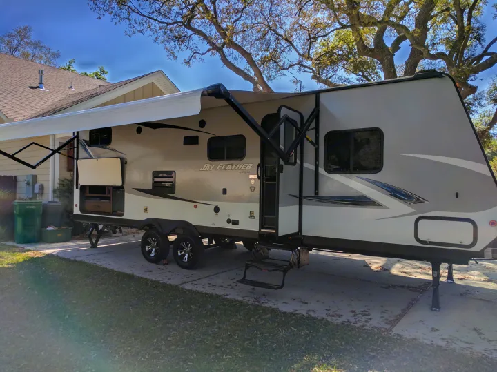 Outdoor two burner stove top with sink and refrigerator located under the awning. . Jayco Jay Feather 2017