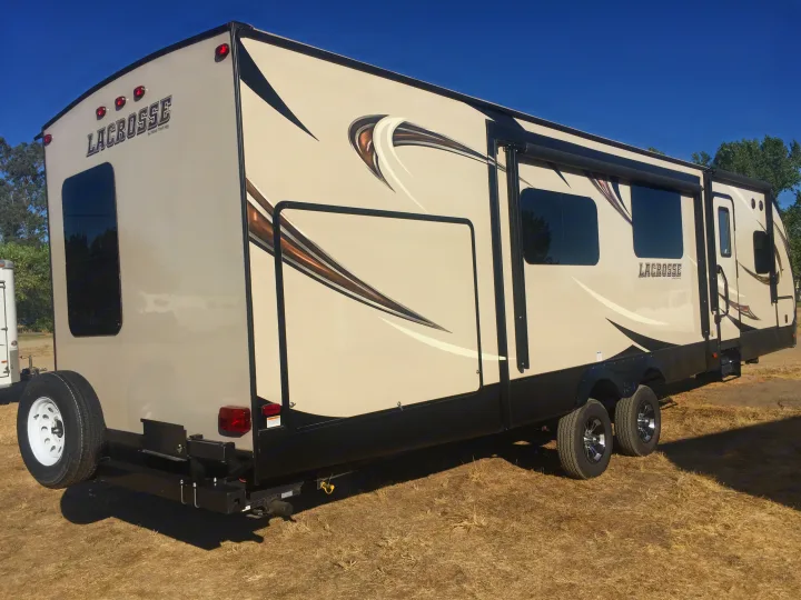 Explore with this LaCrosse travel trailer, a perfect RV rental. The large tan and black recreational vehicle awaits new adventures.. Prime Time Lacrosse 2017