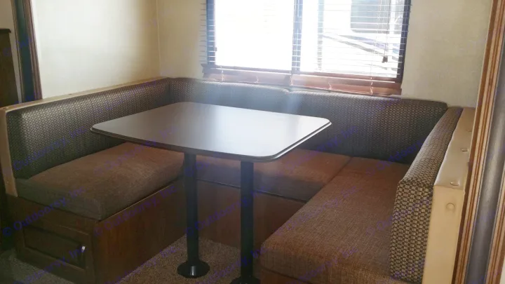 This RV rental's dinette shows U-shaped booth seating, a table, and window blinds. A cozy space for travel.. Forest River Salem Cruise Lite 2018