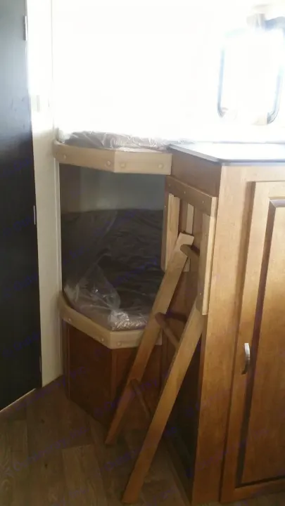 Compact RV rental interior featuring new bunk beds with mattresses, a ladder, and storage cabinets. Ideal sleeping area.. Forest River Salem Cruise Lite 2018