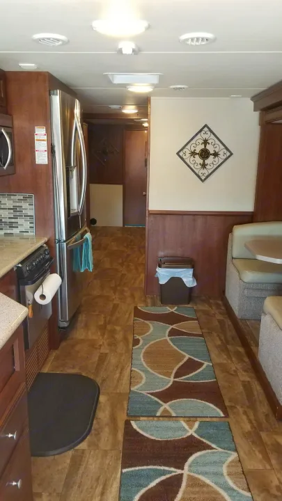 Spacious RV rental interior features full kitchen with fridge, dinette, and hallway, providing comfortable travel.. Forest River Georgetown 2017