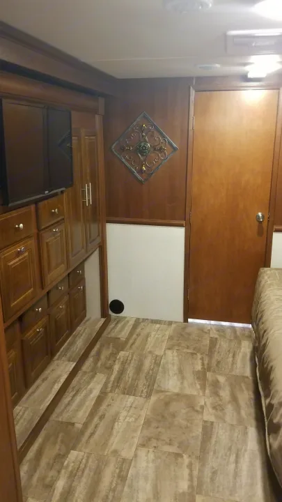 Cozy RV rental interior with wood cabinetry, tiled floors, and a glimpse of the bedroom, perfect for travel.. Forest River Georgetown 2017