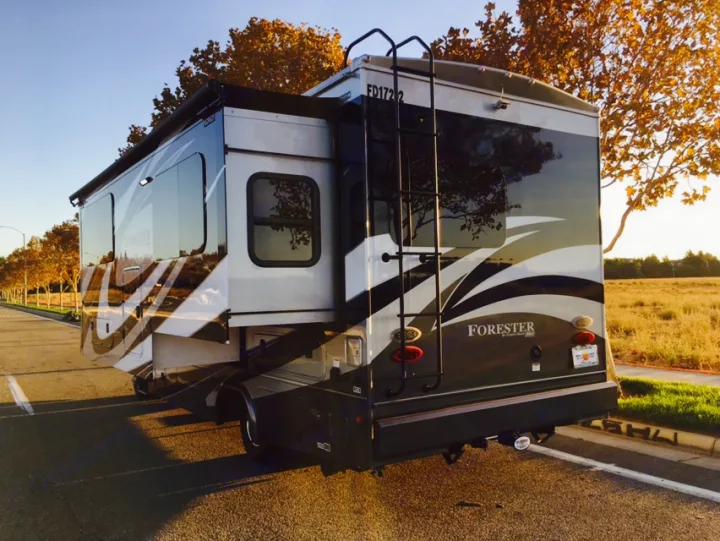 Explore with an RV rental: a modern Forester motorhome with an extended slide-out, parked on a sunny road.. Mercedes Benz Forest River Forester 2017