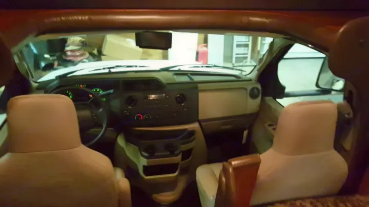 RV rental: Interior view of the front cab, showing driver & passenger seats, dashboard, and steering wheel.. Jayco Redhawk 2016