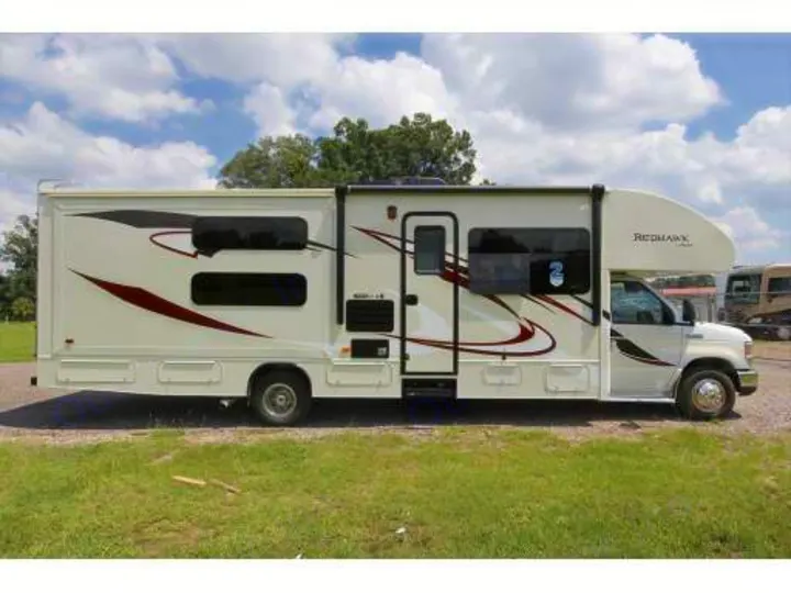 White Jayco Redhawk RV rental, a motorhome with burgundy/black graphics, parked outdoors. Ready for travel!. Jayco Redhawk 2016