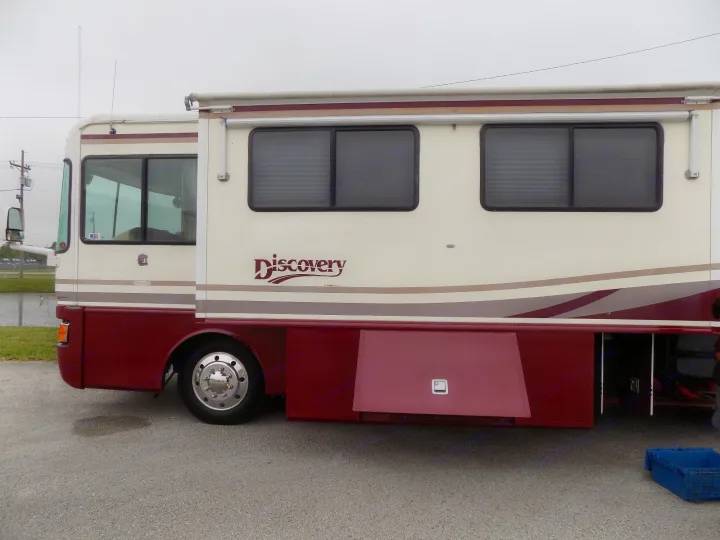 This cream and maroon "Discovery" motorhome, perfect for an rv rental, offers comfort for your next road trip adventure.. Fleetwood Discovery 1998