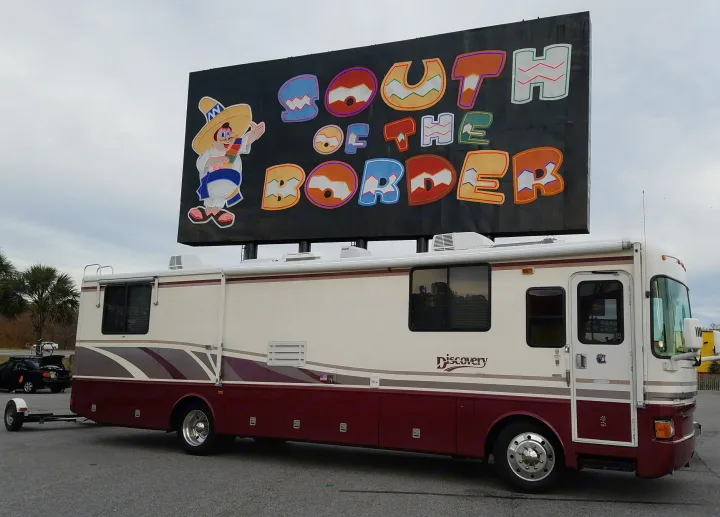 This Discovery RV rental is parked at the colorful "South of the Border" sign, ready for roadside travel adventures.. Fleetwood Discovery 1998