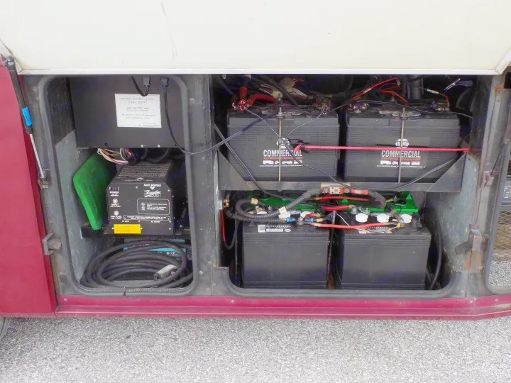 This rv rental's electrical bay shows batteries, inverter, and control center, essential for on-the-go power.. Fleetwood Discovery 1998