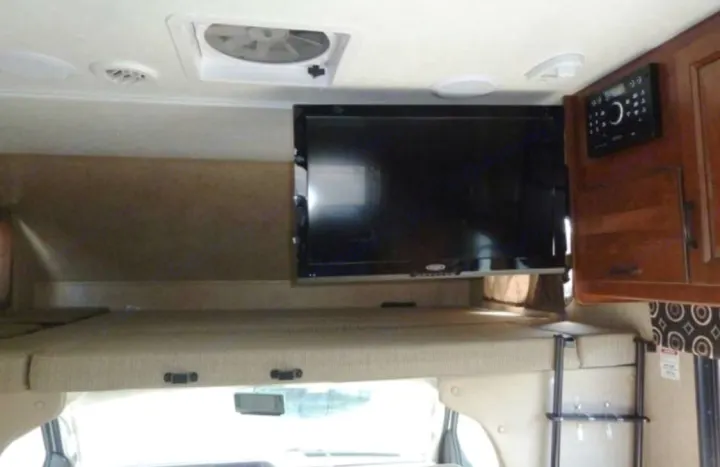 RV rental: Cozy cab-over bunk with flat-screen TV and entertainment system, perfect for road trip comfort.. Forest River Sunseeker 2017