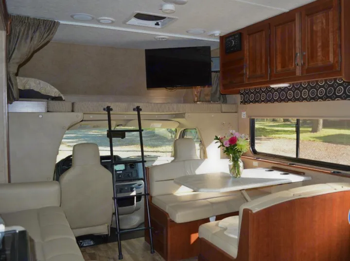 RV rental: Inviting interior featuring a dinette, overhead bunk with ladder, TV, and cab for comfortable travel.. Forest River Sunseeker 2017