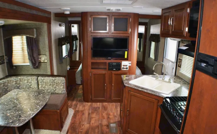 Spacious RV rental interior featuring a full kitchen, dinette, and entertainment center.. Passport BHS 2015
