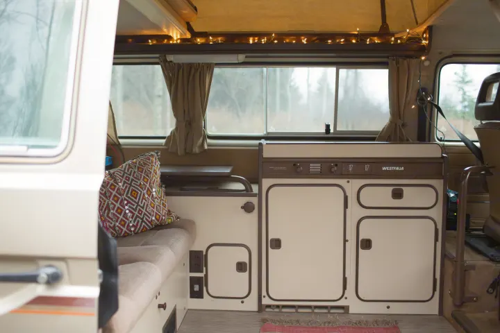 Cozy Westfalia RV rental interior: compact kitchen, comfortable seating, and ambient lighting for your next adventure.. Volkswagen syncro 1986