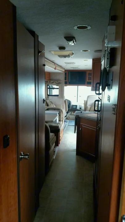 View down the narrow hallway of an RV rental, showing the kitchen on the right and living space ahead. Typical motorhome interior.. National Surf Side 2006