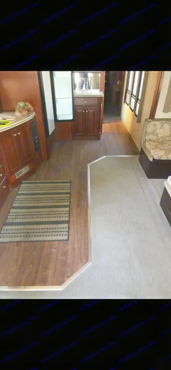RV rental interior: kitchen with wood floor, open fridge, bathroom vanity & carpeted living space with seating.. Thor Mandalay 2006