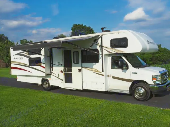 White Class C Sunseeker RV rental with extended slide-out and awning, parked for travel.. Forest River Sunseeker 2017