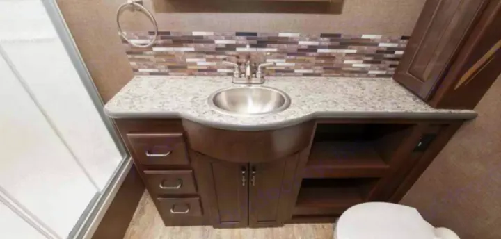 RV rental bathroom boasts a curved vanity with sink, modern faucet, mosaic backsplash, and shower. Compact yet complete.. Thor Motor Coach 35m 2017