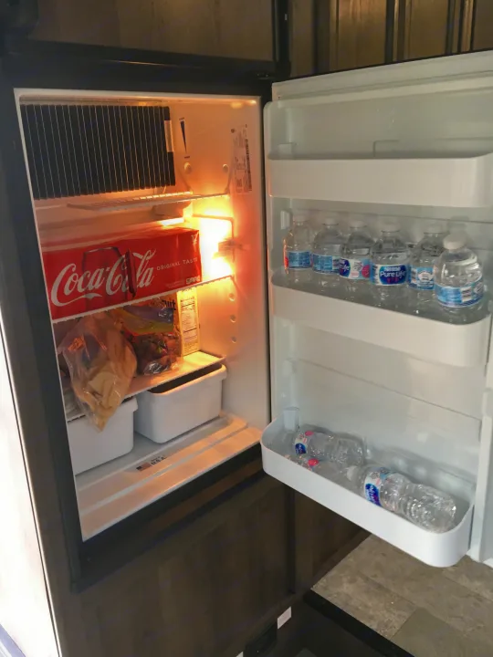 RV rental: Open refrigerator with bottled water, Coca-Cola, and food, a compact amenity for your trip.. Coachmen Freelander 2018