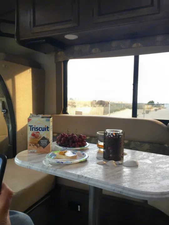 Cozy RV rental setup: Triscuit crackers, grapes, and cheese on a marble table. Coachmen Freelander 2018