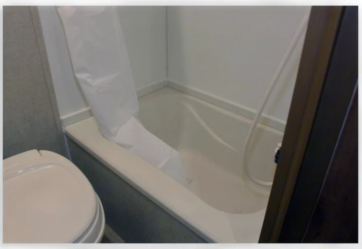 RV rental bathroom with a compact tub/shower combo, white curtain, and toilet, maximizing space for travel.. Gulf Stream Conquest 16BHC 2017