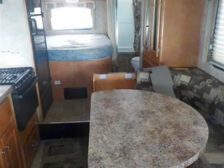 View inside an RV rental: kitchen area, elevated bed, dinette, and visible bathroom. Ideal camper for trips.. Gulf Stream Yellowstone 2009