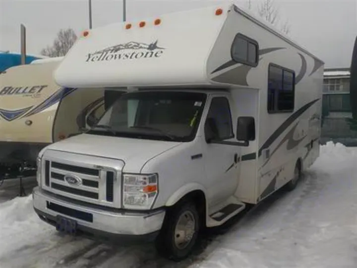 White Yellowstone Class C motorhome for RV rental, parked in snow. This detailed front view shows the spacious vehicle.. Gulf Stream Yellowstone 2009