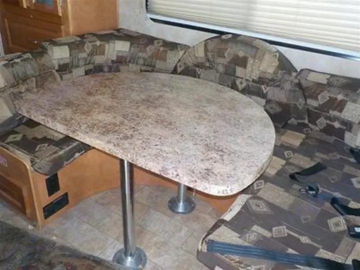 Spacious RV rental dinette featuring comfortable U-shaped seating and a large table for meals.. Gulf Stream Yellowstone 2009