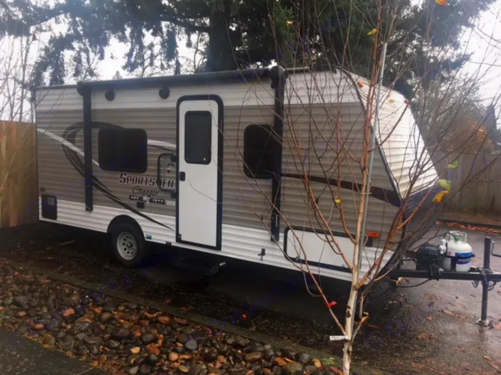 This clean grey & white travel trailer, a Sportsmen Classic RV rental, is ready for outdoor adventures.. KZ SPORTSMEN 2017