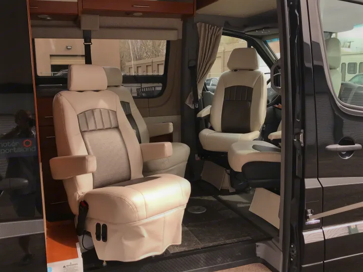 Luxurious rv rental interior shows swivel captain's chairs and a spacious living area in a Mercedes-Benz Sprinter van.. Winnebago Era 2014
