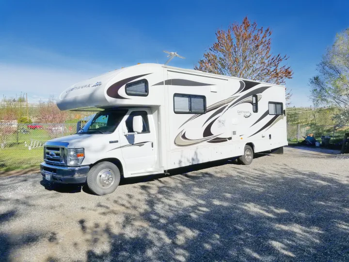 White Jayco Greyhawk Class C RV rental parked on gravel under a blue sky, ready for your next adventure.. Jayco Greyhawk 2011