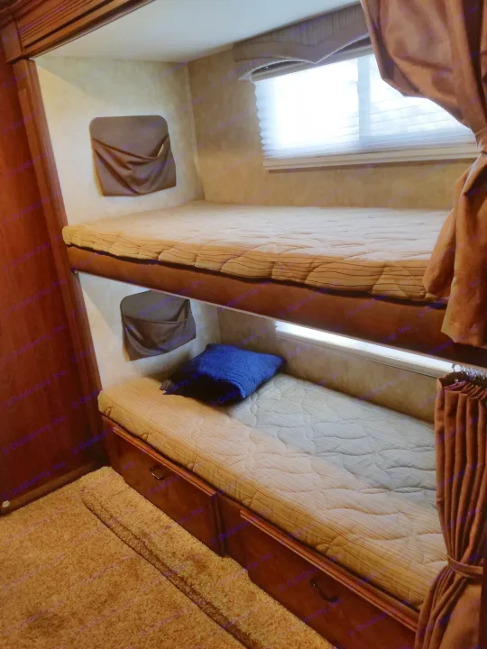 Cozy RV rental bunk beds with a window, storage, and bedside organizers for a comfy stay.. Jayco Greyhawk 2011