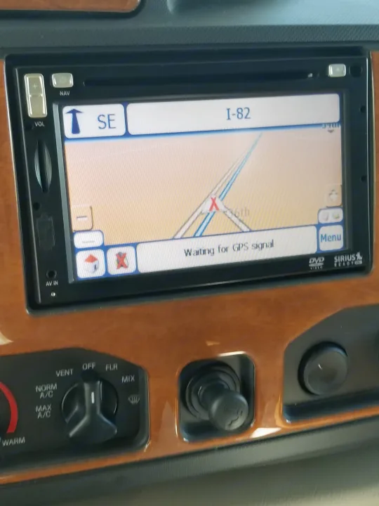 An RV rental dashboard showing a navigation system with I-82 on the map, displaying "Waiting for GPS signal," next to HVAC controls.. Jayco Greyhawk 2011
