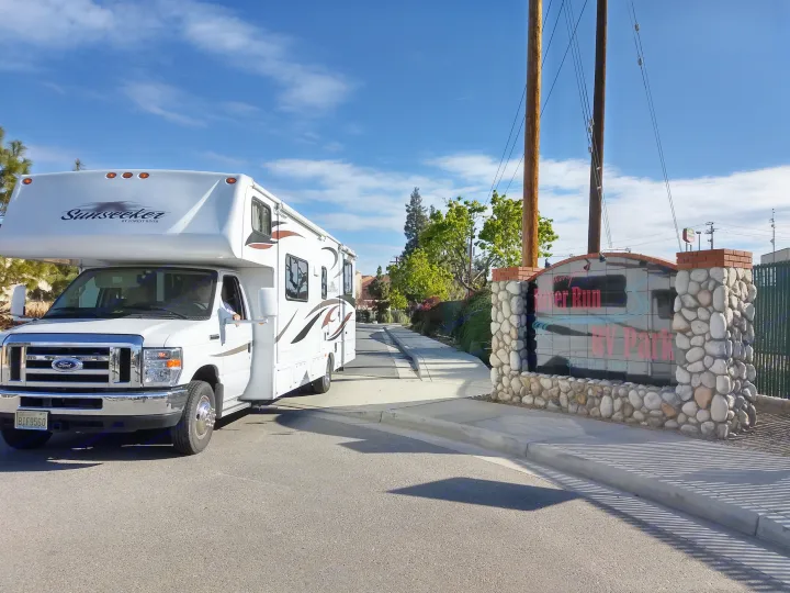 A white Sunseeker RV rental with a Washington plate enters River Run RV Park on a sunny day, ideal for travel.. Forest River Sunseeker 2013