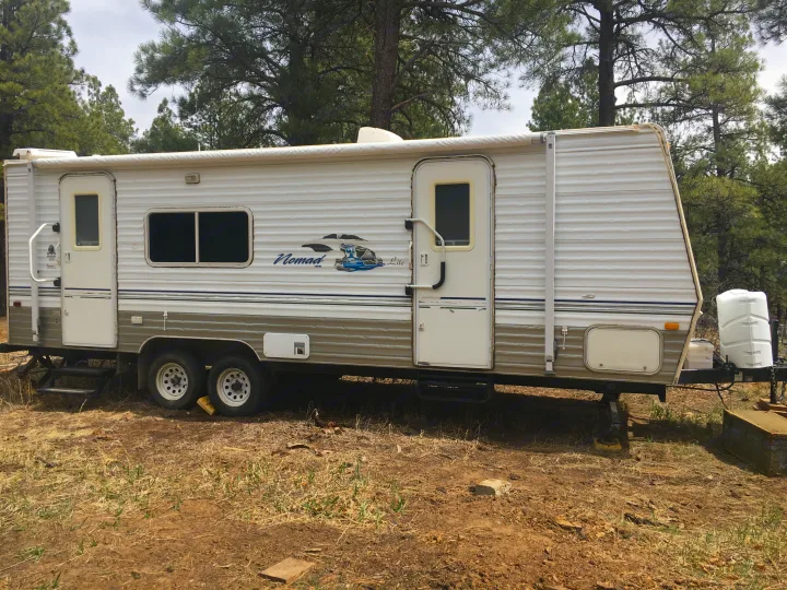 Exterior of camper with awning. Entrance to kitchen on left and private entrace to bedroom on right.. Skyline Other 2006