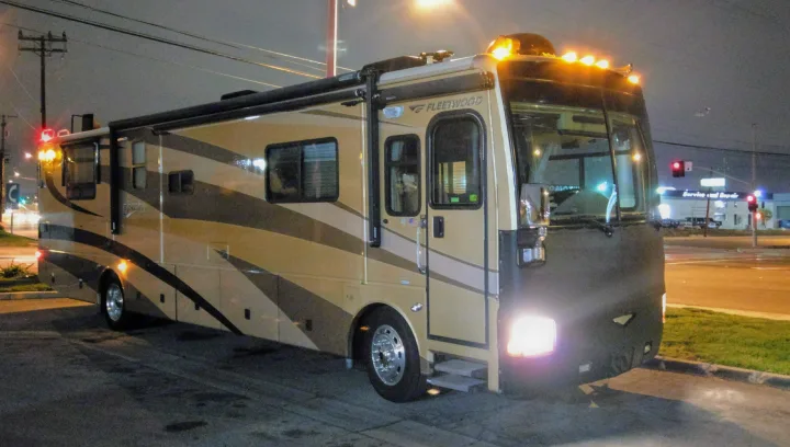 A large, well-lit Fleetwood RV rental is parked at night, ready for your next road trip adventure.. Fleetwood Discovery 2005