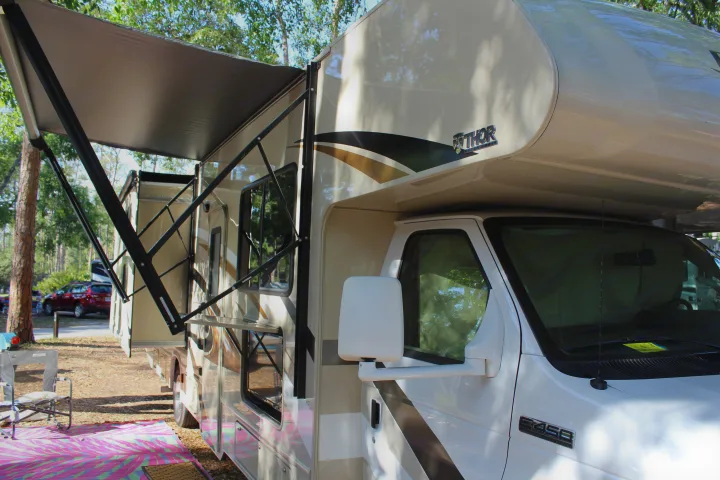 This is the passenger side of the camper.  You can see the canopy partially (there was a tree in the way) extended shading the outdoor tv.  The mat is down, which helps cut down on tracked in dirt.  . Thor Motor Coach Freedom Elite 2017
