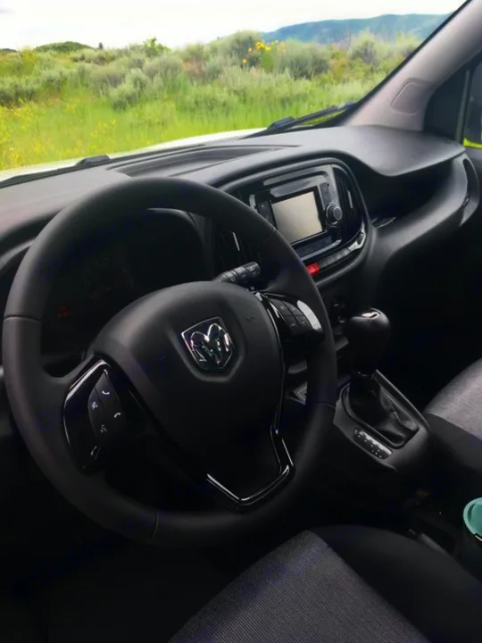 Inside a Ram van, ideal for an rv rental adventure. Features steering wheel, dash, and a scenic mountain landscape.. Ram Promaster City 2018