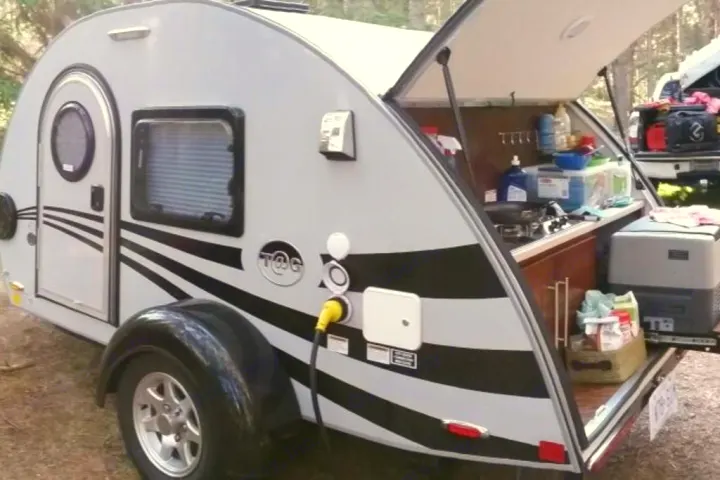 This T@G teardrop RV rental showcases its unique rear kitchen setup, perfect for outdoor cooking and camping trips.. Little Guy Silver Shadow 2016