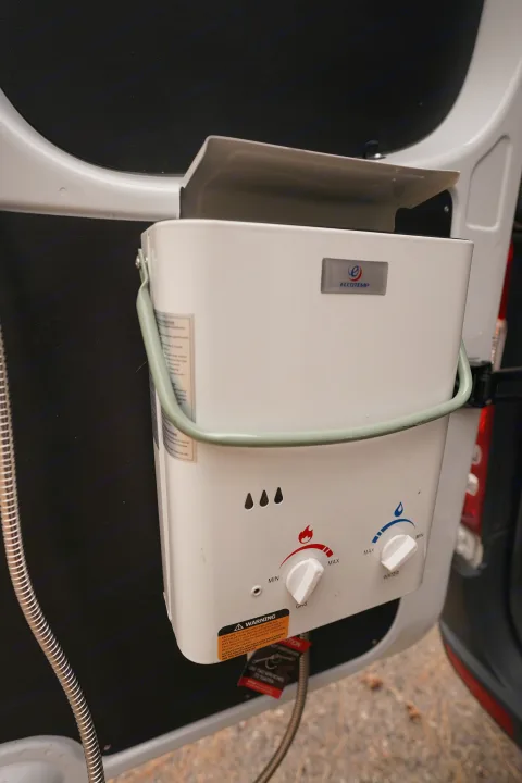 An Eccotemp portable water heater provides an outdoor shower in this RV rental, offering convenience for campers.. Freightliner Sprinter 2016