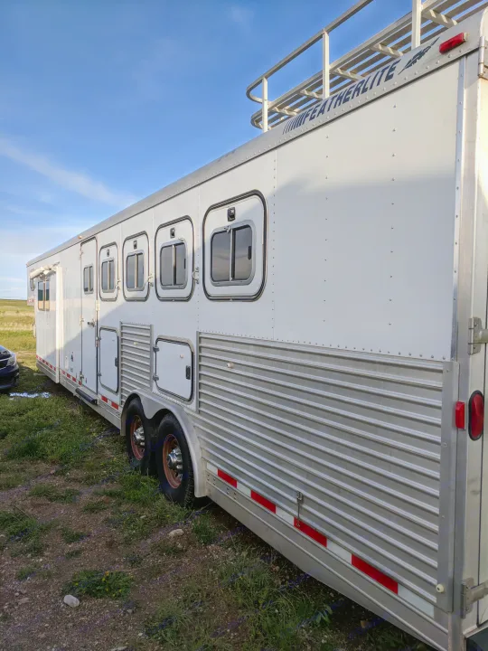 Left side. Drop down windows and more storage.
. Featherlight Trailers LQ w/slide out, 5 Horse slant load 2000