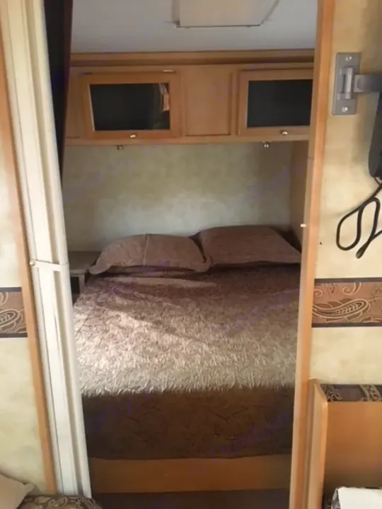 Queen bed with night stands attached.  plugs on left side. Starcraft Starstream 2009
