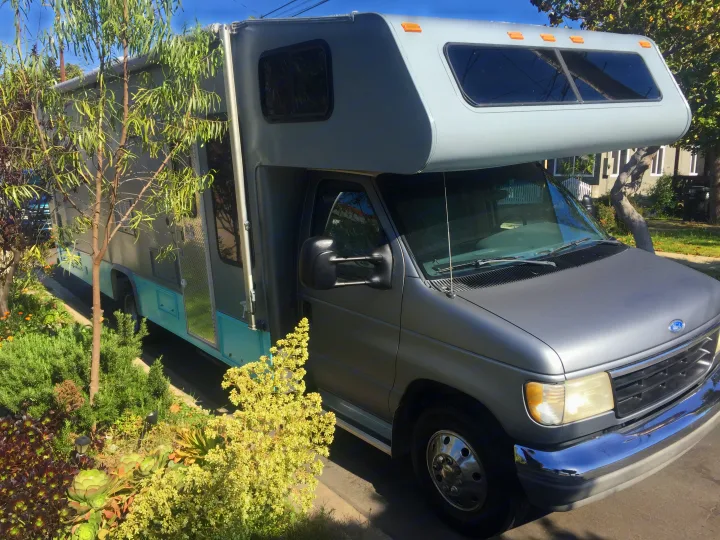 Light gray Ford Class C RV, with teal accents & a custom body, parked roadside. Great for an RV rental getaway!. Other Other 1992