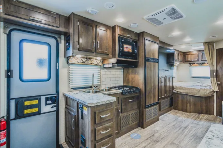 Spacious RV rental interior featuring a modern kitchen, cozy bedroom, and full amenities for comfortable travel.. Jayco Redhawk 2018