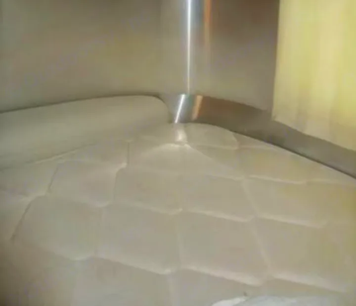 Cozy RV rental sleeping area featuring a quilted mattress, silver interior walls, and a window. Perfect for travel comfort.. Airstream Sport 2015