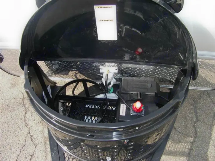 Inside an RV rental's front bay, revealing battery, red disconnect switch, and wiring for essential power.. Little Guy Silver Shadow 2016