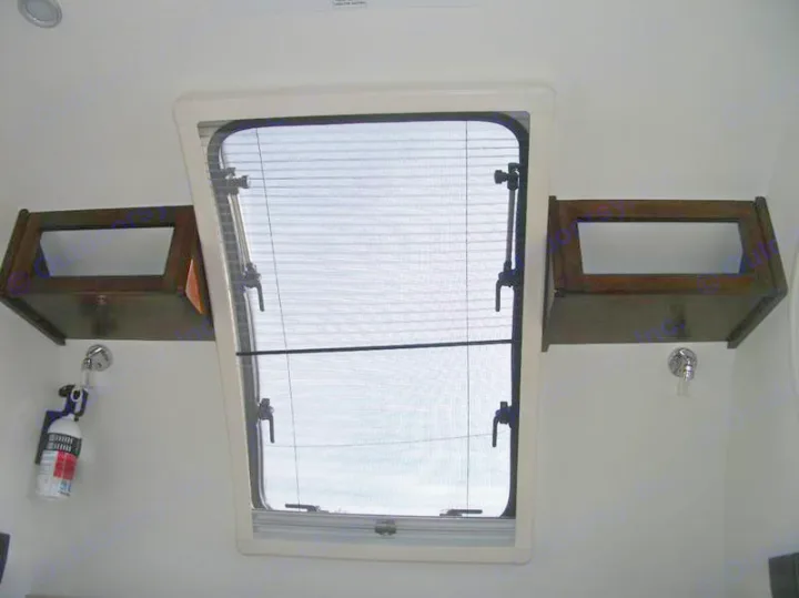 RV rental interior: large skylight/window with screen, overhead storage shelves, and fire extinguisher mounted below.. Little Guy Silver Shadow 2016