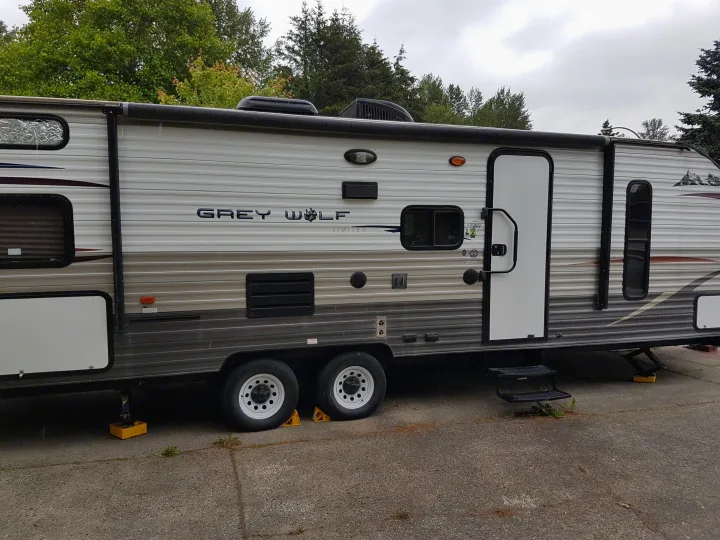 Grey Wolf RV rental: Side view of a travel trailer with white and gray siding, parked on asphalt, stabilized for use.. Grey wolf Other 2015