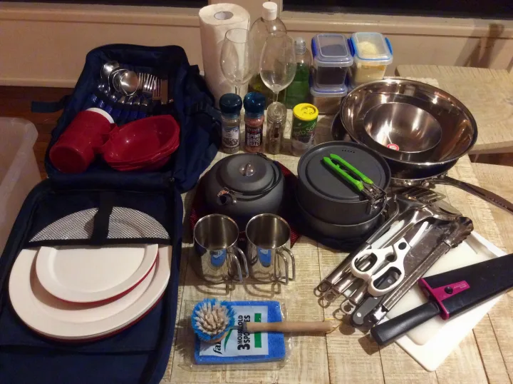 Preparing for an RV rental adventure: Compact kitchen kit with pots, plates, utensils, mugs, and spices.. Volkswagen Transporter T5 2005