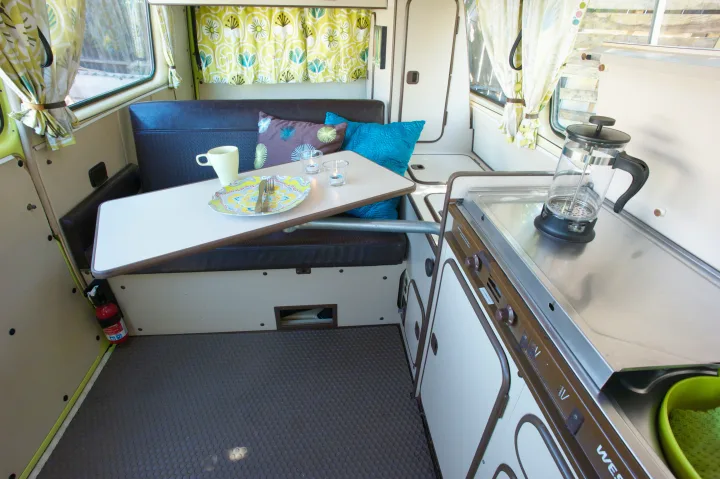 Step inside this bright RV rental. Enjoy a dining area with a table, comfy bench seating, and a functional kitchenette.. Volkswagen westfalia 1984