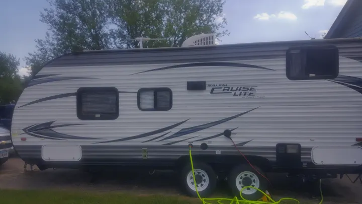 This Salem Cruise Lite travel trailer, ideal for an RV rental, is connected at a campsite with power, water, and roof AC.. Forest River Salem Cruise Lite 2017